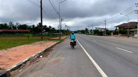 Rückansicht-Von-Frauen,-Die-Bei-Regenwetter-In-Der-Provinz-Nan,-Thailand,-Fahrrad-Fahren