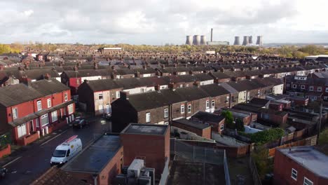 Power-station-on-industrial-town-skyline-aerial-view-descending-rooftops-to-autumn-sunlit-townhouses