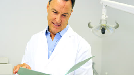 retrato de un dentista sonriente mirando el archivo