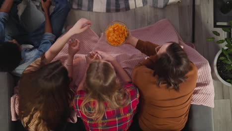 el hombre trata a las mujeres con papas fritas viendo series de televisión juntos