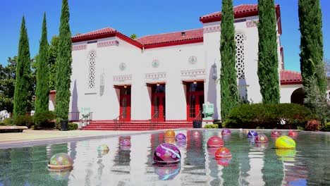 Establishing-shot-of-a-classic-California-public-building-with-fountain-and-art-objects-foreground