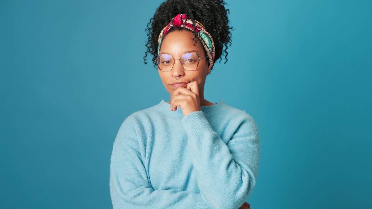 Thoughtful Young Woman Pondering and Smiling in Studio