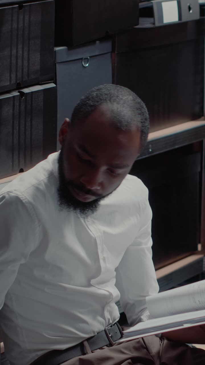 Vertical video: Private detective conducting investigation sitting on floor