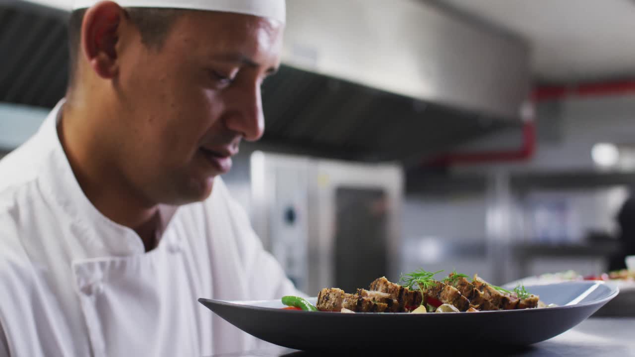 cocinero caucásico adornando platos y sonriendo en la cocina del restaurante