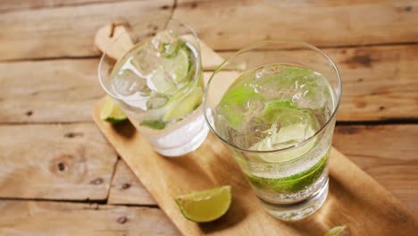 close up of drinks with lemons on wooden board