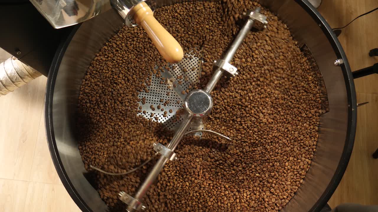 wide shot of roasting machine is rotating and cooling the roasted coffee beans
