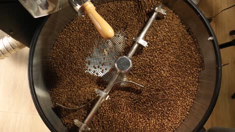 wide shot of roasting machine is rotating and cooling the roasted coffee beans