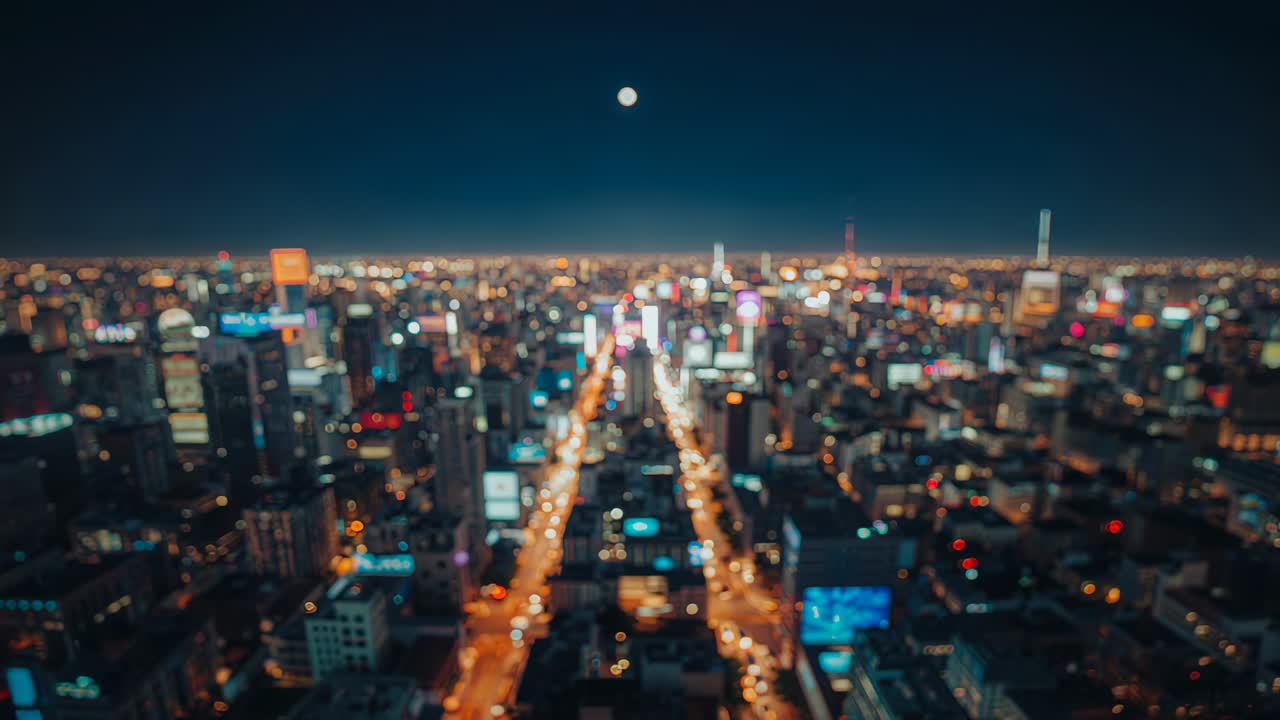 Tilting aerial camera moving over avenue at night, following moon appearance to reveal neon signs