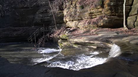 forest river cascading down small rocky steps in rocky valley