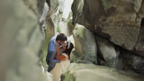 groom with bride standing in cave of mountain hills. wedding couple in love