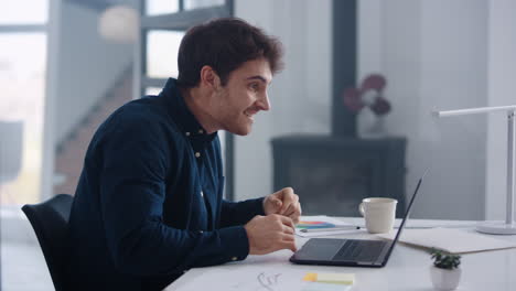 Happy-business-man-working-on-laptop-computer-in-office.-Guy-winning-project