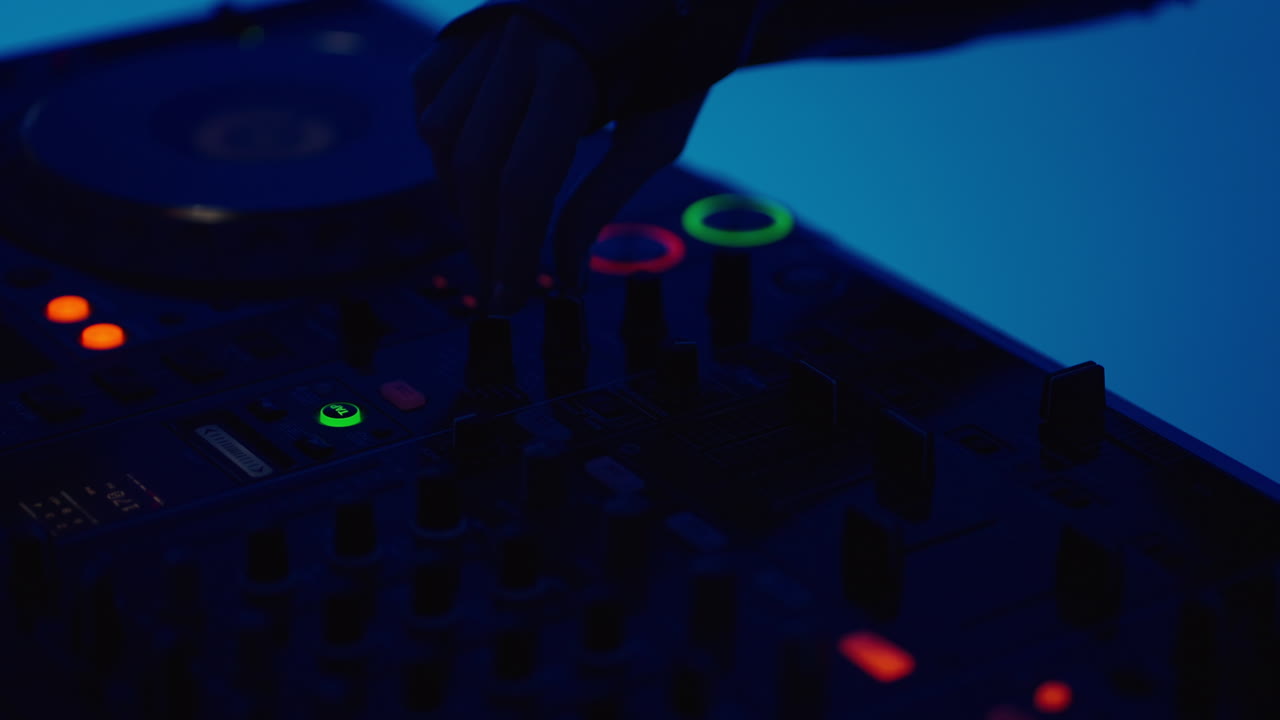 dj mezclando música en un mezclador con iluminación azul