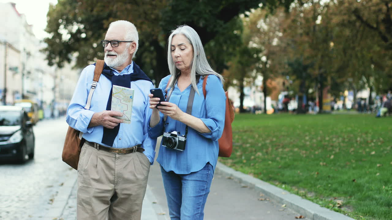 pareja mayor de turistas caminando y hablando en la ciudad