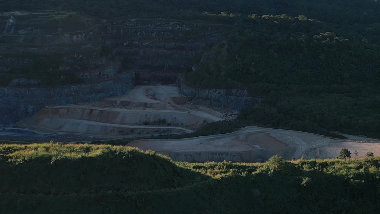 Terrasseret stenbrudsgravning nær Brasília, Distrito Federal, Brasilien, sidelæns drone-slide-skud over industriel mineinfrastruktur og barskt Cerrado-højlandsterræn