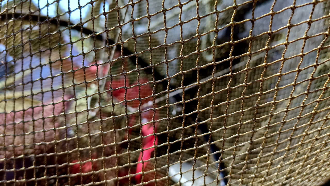 Close-up view of a fishing net with blurred background of fishing gear and equipment