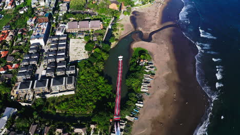 colorida cometa janggan con cola larga volando alto sobre la costa del mar, bali