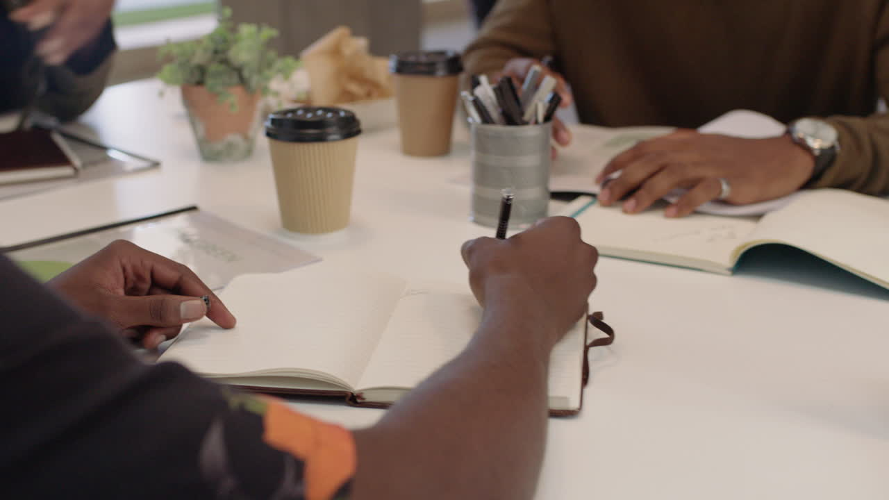 des hommes d'affaires noirs se rencontrent, font un brainstorming, un chef d'équipe, une femme présente des données financières en utilisant la technologie des tablettes, partagent la stratégie du projet, des collègues travaillent ensemble dans la salle de réunion du bureau.