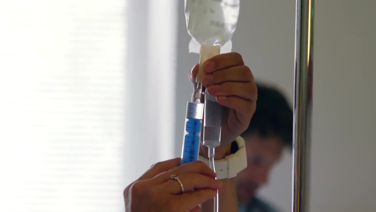 간호사가 주사에 약을 주사하고 있습니다.