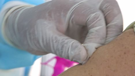 Close-up-shot-of-doctor-with-gloves-injecting-syringe-with-Coronavirus-Covid-19-Injection