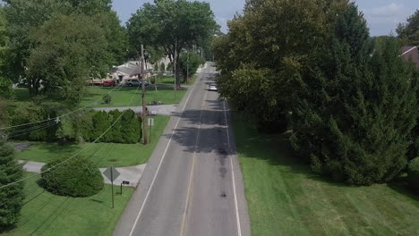 cars driving on suburban back road in small town