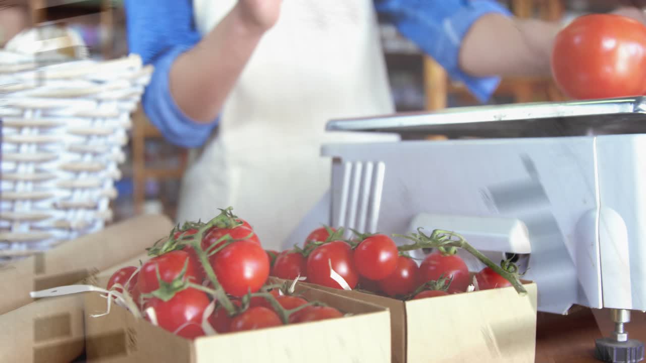 Venditore di ortaggi che prende i pomodori dal bancone, li mette sulla bilancia con una sovrapposizione grafica che mostra il prezzo