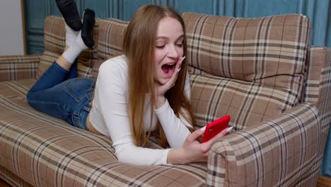 joyful girl reading good news, enjoy success shopping, celebrating lottery victory on mobile phone