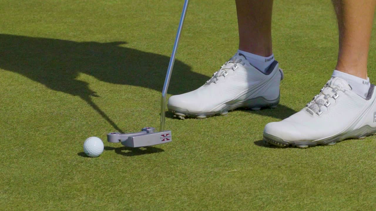 골프 그린에서 퍼팅 기술을 연습하는 골퍼의 클로즈업 샷