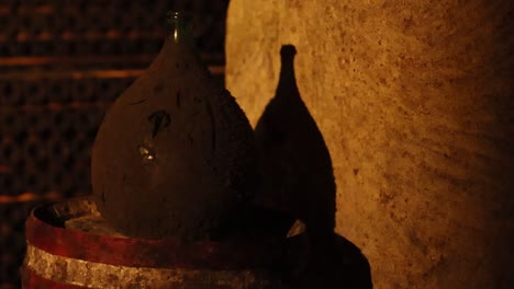 a single dusty vase rests on a weathered barrel, illuminated by warm, dim lighting.