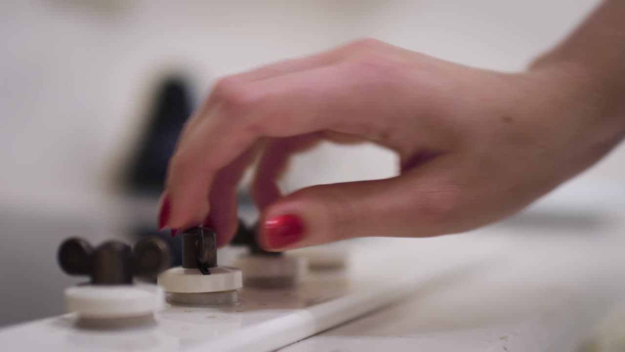 mano femenina girando la perilla de la estufa de gas en la cocina en la cocina