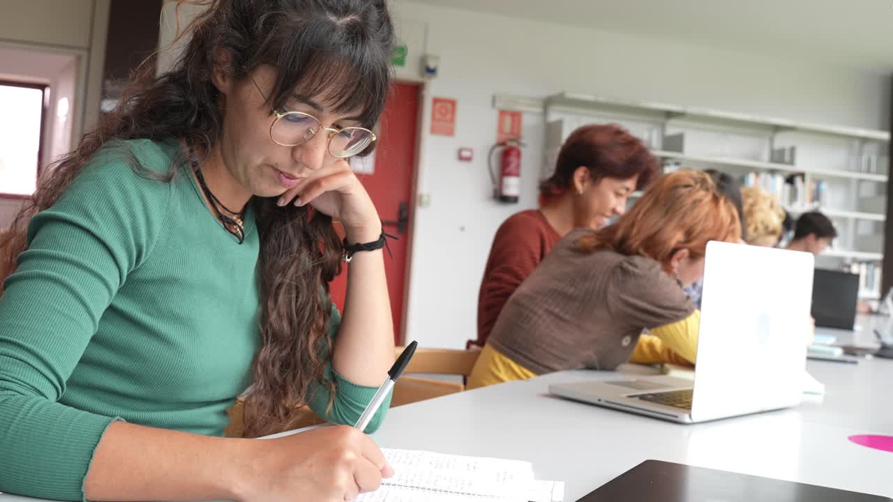 mujeres jóvenes que trabajan en un proyecto en la biblioteca
