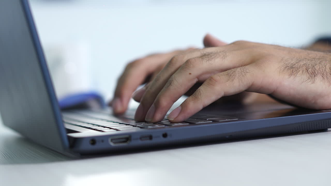 manos escribiendo en un teclado de portátil, ilustrando el acto moderno y eficiente de la comunicación digital