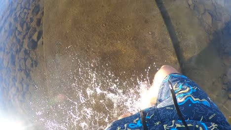 a pov super slow motion shot of a white man in blue swim shorts walking into the sea at the beach in norway