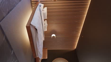disparo vertical de un dormitorio moderno con iluminación de fondo y pared de madera, disparo panorámico