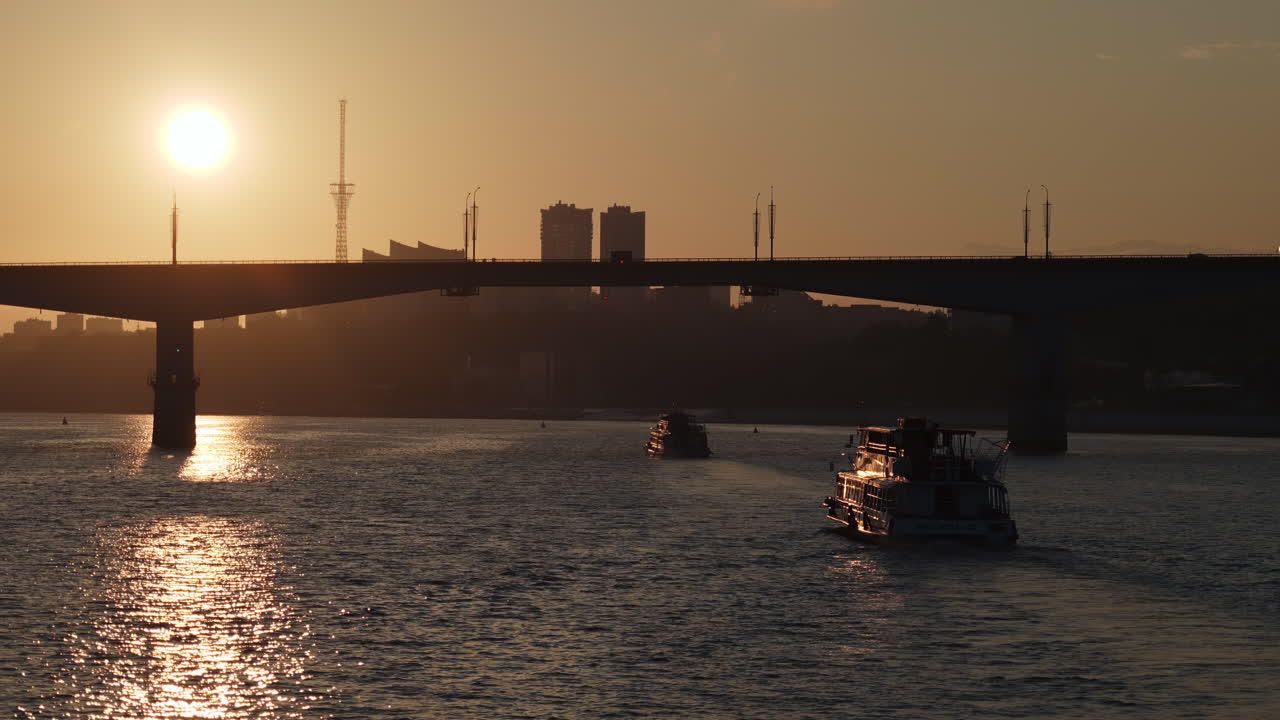 Boats on a River Under a Bridge at Sunset