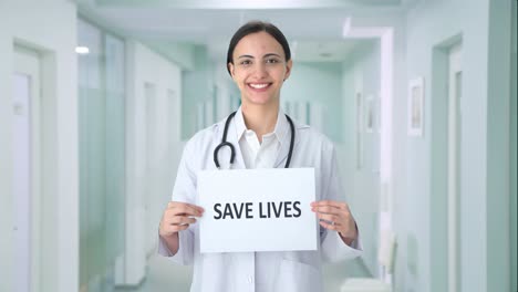 happy indian female doctor holding save lives banner