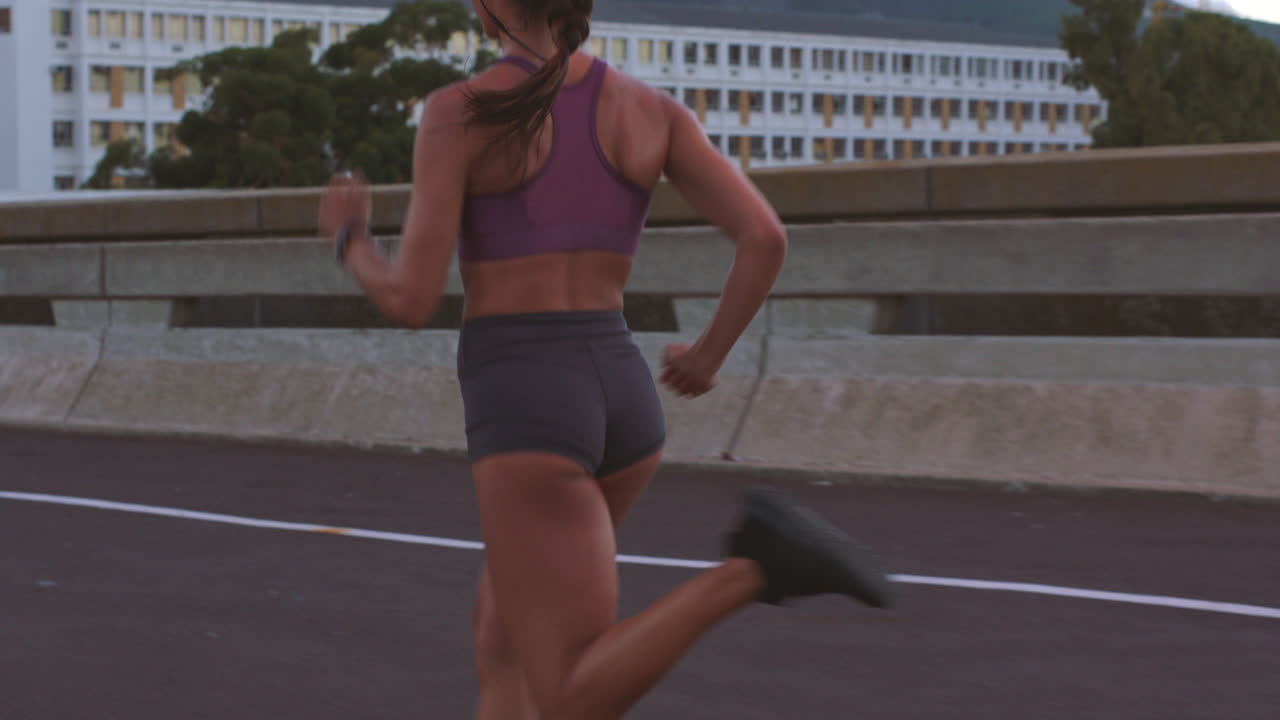 mujer corriendo en un puente de la ciudad