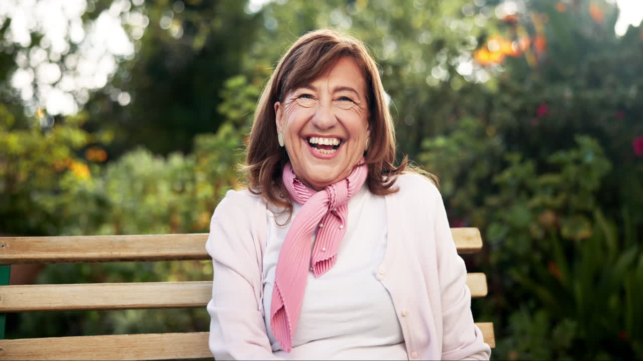 Senior woman laughing on a park bench
