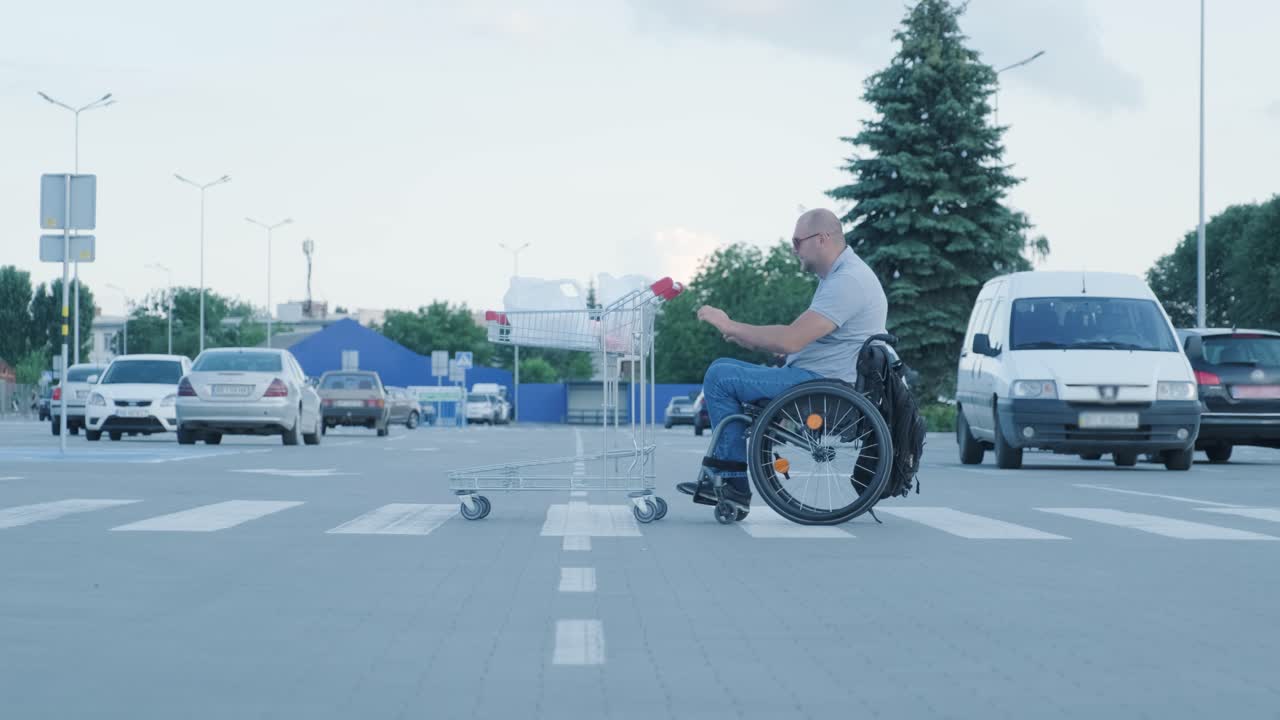 Man with disabilities in wheelchair pushing cart in front of himself at supermarket parking