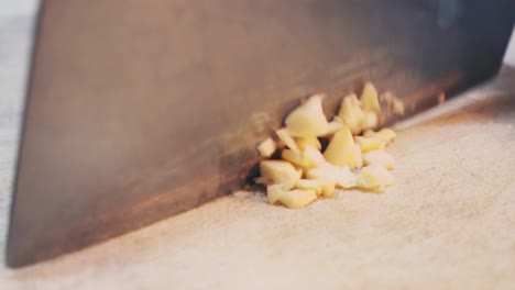 a chef slices garlic on chopping board close up