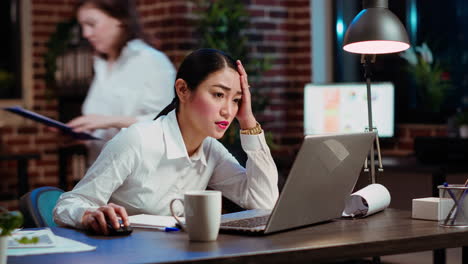 worker gasping while looking at laptop screen, feeling disappointed