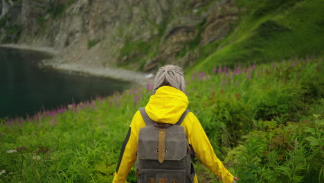 woman hiking in a scenic mountainous landscape with a view of the coastline