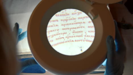 examining an ancient manuscript with a magnifying glass