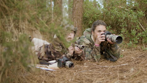 Caucasian-woman-and-her-son-lying-on-the-ground-and-watching-birds-in-a-natural-park