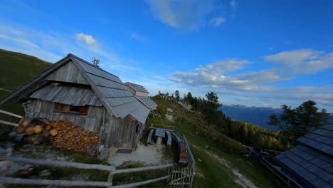 fpv footage was filmed in the slovenian mountain village in the alps with a drone flying fast over mountains filmed with a gopro with surrounding landscapes flying between and over small wooden cabins-7