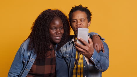 Happy-couple-waving-at-webcam-and-talking-to-friends-group-remotely