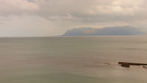Calm seascape with a distant view of mountains on the coast of Sicily