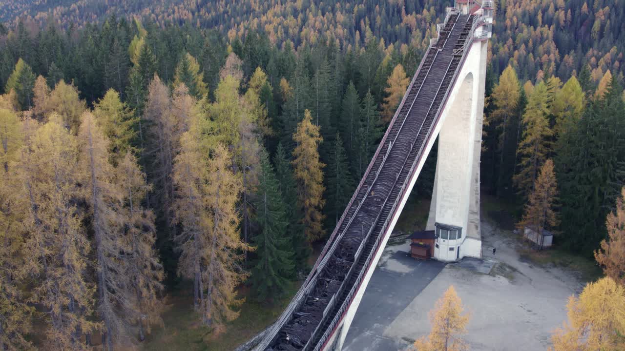 Ilmakuva Dolomittien huipuista syksyllä hiihtohypyn maamerkin kera, Cortina, Italia