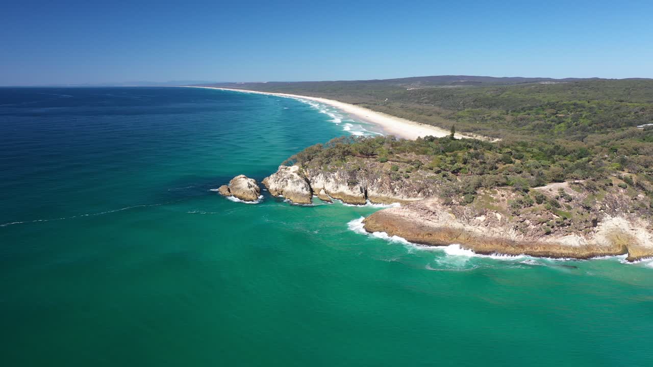 Beautiful aerial view of blue pristine water with surfers and gentle waves