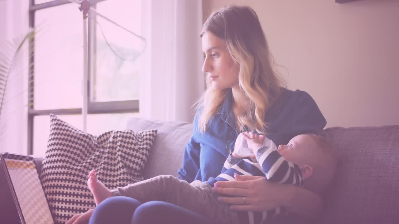 animación de iconos de corazón sobre una madre caucásica sosteniendo a su bebé