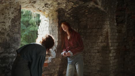 two women talking in an old castle ruin